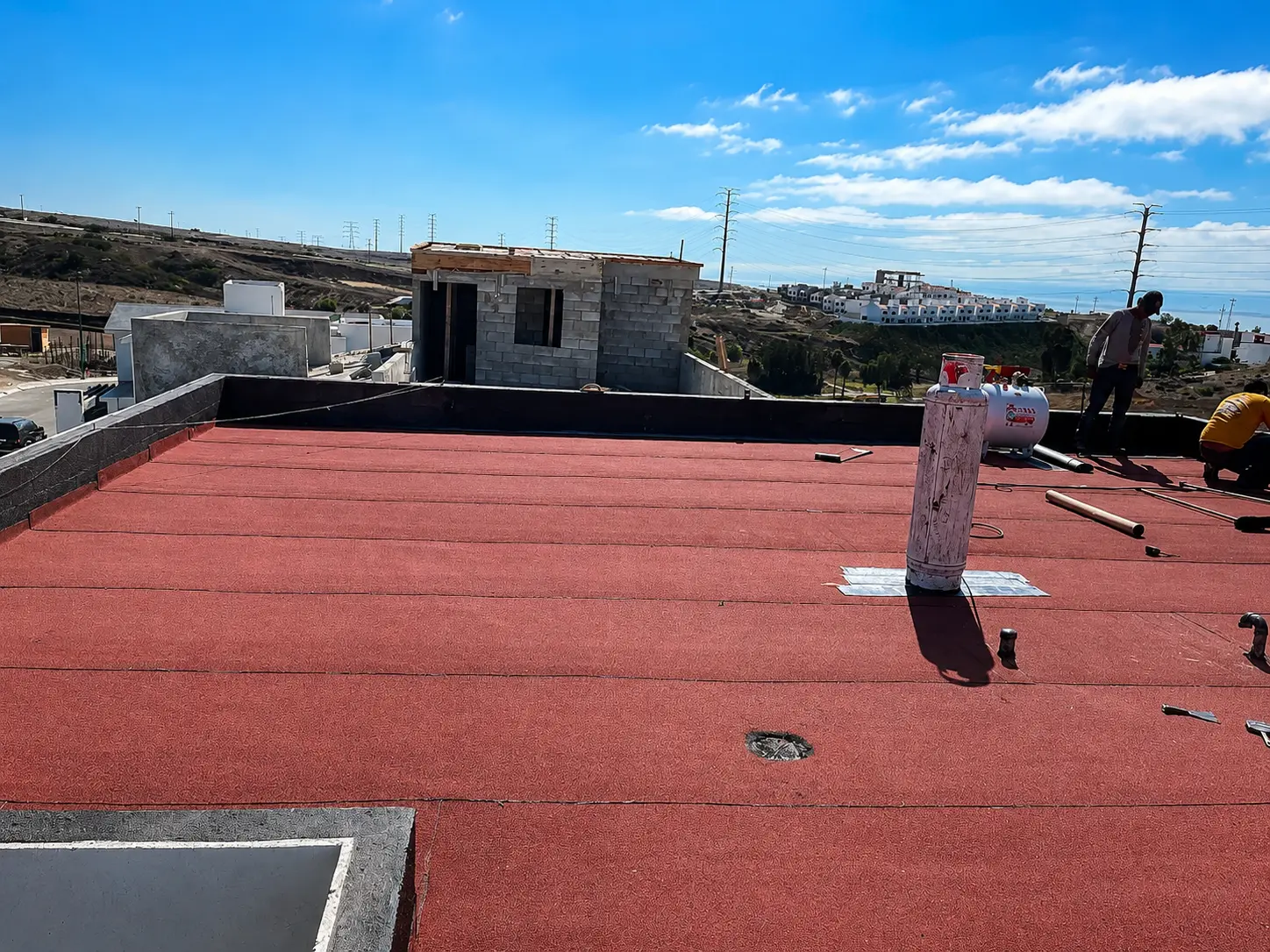 Avance de impermeabilización con manto rojo sobre losa de concreto residencial