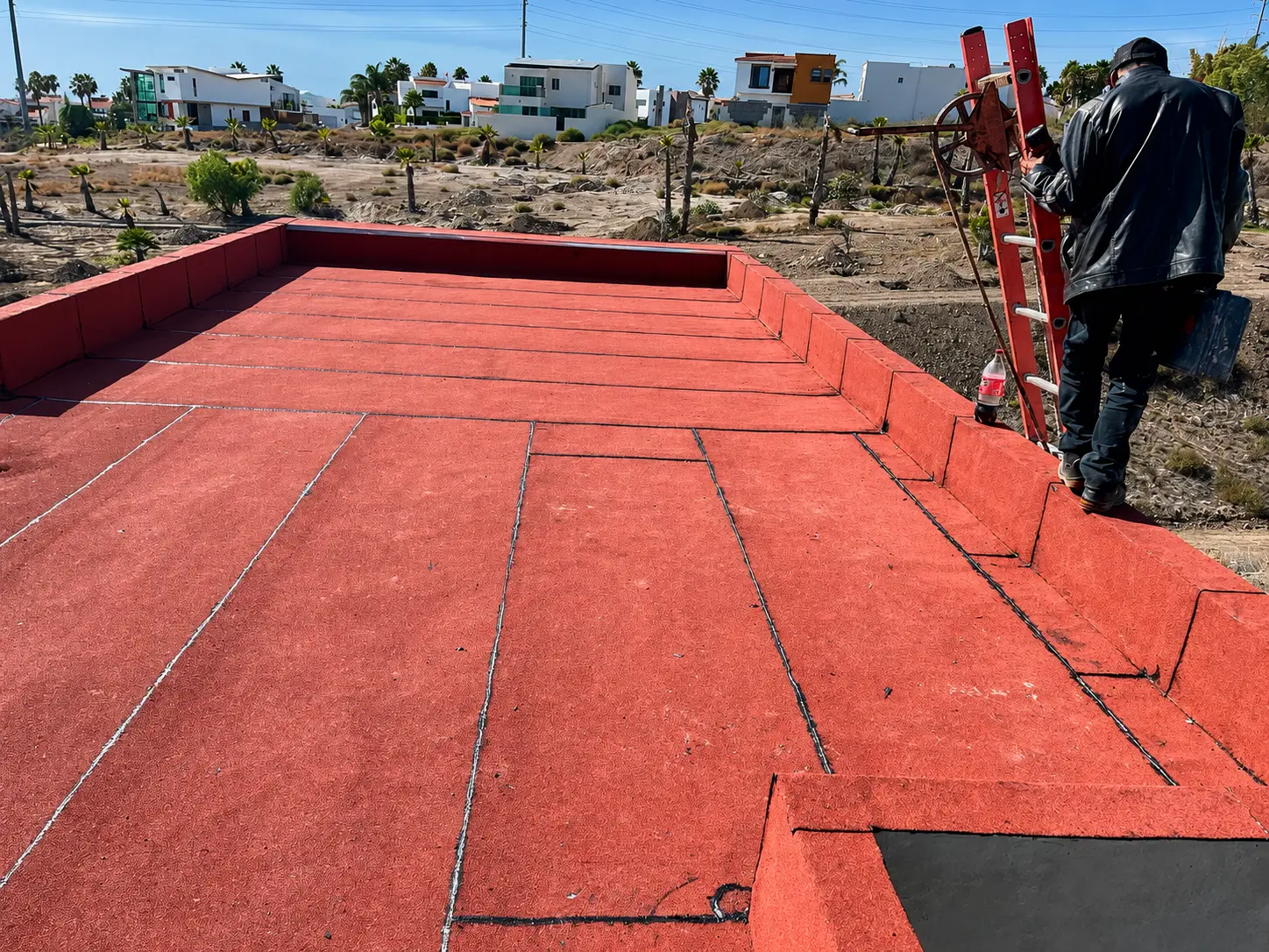Manto asfáltico rojo terminado con traslapes sellados y pretiles forrados